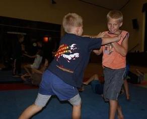 The kids learn how to deal with an attacker which grabs hold of them. Dominating the clinch range is an important part of their training